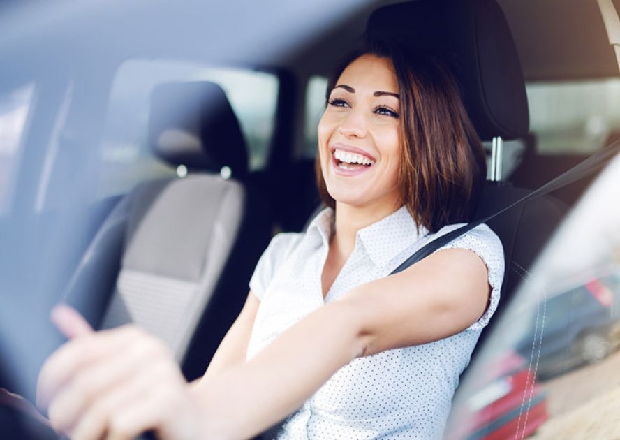 woman smiling while driving car