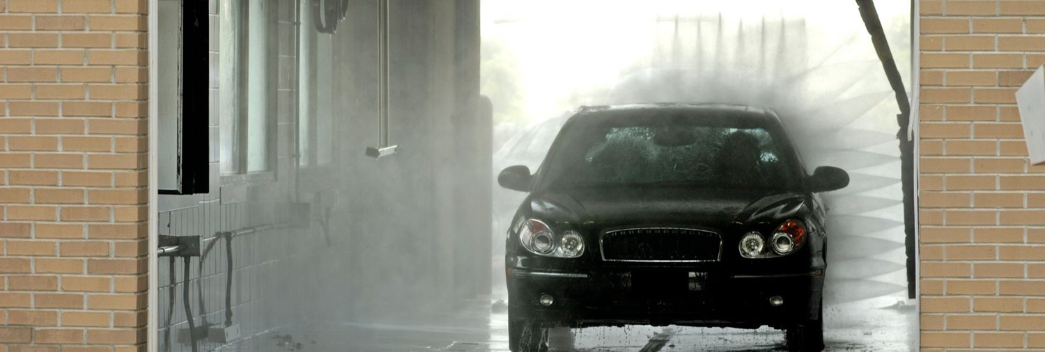 black vehicle inside an in-bay automatic car wash